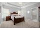 Spacious bedroom with soft carpet, neutral paint, tray ceilings, and ensuite bathroom at 6325 Haddington Ln, Suwanee, GA 30024