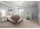 Well-lit bedroom showcasing a tray ceiling, soft carpet, white furnishings, and a writing desk at 6325 Haddington Ln, Suwanee, GA 30024