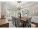 Elegant dining room with large windows, stylish chandelier, wood floors and trim work at 6325 Haddington Ln, Suwanee, GA 30024