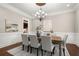 Elegant dining room with large windows, stylish chandelier, wood floors, trim work, and decorative wall art at 6325 Haddington Ln, Suwanee, GA 30024