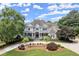 Beautiful two-story home featuring manicured front lawn and driveway with lush, mature landscaping and a welcoming front porch at 6325 Haddington Ln, Suwanee, GA 30024
