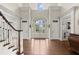 Grand foyer with high ceilings, hardwood floors, arched glass doors, transom windows and staircase with wood banister at 6325 Haddington Ln, Suwanee, GA 30024