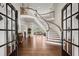 Elegant foyer with curved staircase, hardwood floors, and a view into the living room through glass french doors at 6325 Haddington Ln, Suwanee, GA 30024