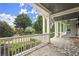 Spacious covered front porch with stone flooring, white railing, and views of the landscaped front yard at 6325 Haddington Ln, Suwanee, GA 30024