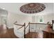 Hallway featuring curved staircase, decorative ceiling, and natural light at 6325 Haddington Ln, Suwanee, GA 30024