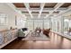 Spacious living room featuring coffered ceilings, hardwood floors, large windows, and access to the outdoor patio at 6325 Haddington Ln, Suwanee, GA 30024
