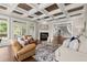 Bright living room featuring a fireplace, hardwood floors, and elegant coffered ceilings at 6325 Haddington Ln, Suwanee, GA 30024