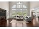 Bright living room with large arched windows, hardwood floors, and comfortable seating area at 6325 Haddington Ln, Suwanee, GA 30024