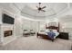 Luxurious main bedroom features a fireplace, tray ceiling, and four-poster bed at 6325 Haddington Ln, Suwanee, GA 30024