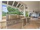 Outdoor kitchen featuring stainless steel grill, sink, and stone countertop at 6325 Haddington Ln, Suwanee, GA 30024