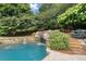 Beautiful pool with waterfall feature and stone surround, set within a landscaped backyard at 6325 Haddington Ln, Suwanee, GA 30024
