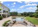 Inviting backyard pool with spa, stone waterfall, and lush landscaping at 6325 Haddington Ln, Suwanee, GA 30024