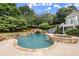 Backyard pool and spa area featuring a waterfall, stone accents, and lush landscaping at 6325 Haddington Ln, Suwanee, GA 30024