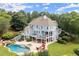 Aerial view of an outdoor living space with a pool, spa, covered patio, outdoor kitchen, and a fire pit with seating at 6325 Haddington Ln, Suwanee, GA 30024