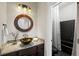 Charming bathroom featuring granite counters, dark wood cabinets, a unique sink, and a tiled shower at 410 Waterridge Ct, Sandy Springs, GA 30350