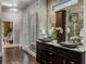 Luxury bathroom featuring a double sink vanity, designer mirrors, and stone walls at 410 Waterridge Ct, Sandy Springs, GA 30350