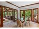 Bright dining room with modern glass table, wood trim, and doors to a cozy sunroom at 410 Waterridge Ct, Sandy Springs, GA 30350