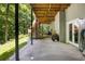 A covered outdoor patio area featuring stone flooring and steps to an elevated wooden deck at 410 Waterridge Ct, Sandy Springs, GA 30350