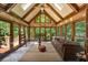 Cozy sunroom featuring a stone wall, vaulted ceilings, skylights, and ample natural light at 410 Waterridge Ct, Sandy Springs, GA 30350