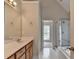 Bright bathroom featuring a vanity with a large mirror and an adjoining shower at 430 Tara Oaks Ct, Lawrenceville, GA 30043