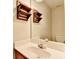 Well-lit half-bath featuring a white sink and wooden accent shelves at 430 Tara Oaks Ct, Lawrenceville, GA 30043