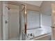 Bright bathroom featuring a glass-enclosed shower and a jacuzzi tub near a window at 430 Tara Oaks Ct, Lawrenceville, GA 30043