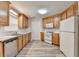 Spacious kitchen featuring wood cabinets, white appliances, and tile flooring at 430 Tara Oaks Ct, Lawrenceville, GA 30043