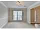 Bright, carpeted living room featuring crown molding, and large windows at 430 Tara Oaks Ct, Lawrenceville, GA 30043