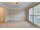 Bright, carpeted living room featuring crown molding, and large windows at 430 Tara Oaks Ct, Lawrenceville, GA 30043