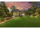 Picturesque backyard featuring mature trees, lush lawn, and elevated deck at 2455 Stonevalley Ln, Cumming, GA 30041