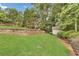 Well-maintained backyard with retaining wall, shed, and ample greenery at 2455 Stonevalley Ln, Cumming, GA 30041