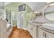 This bathroom features double sinks, granite counters, wood-look tile flooring, and a soaking tub at 2455 Stonevalley Ln, Cumming, GA 30041