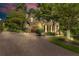 Exterior evening shot of a long driveway leading to the side of the home at 2455 Stonevalley Ln, Cumming, GA 30041