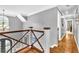 This home features a hallway with hardwood floors, wood and cable railing, and decorative lighting at 2455 Stonevalley Ln, Cumming, GA 30041