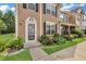 Exterior view of a townhouse with manicured landscaping and a sidewalk at 3028 Sw Deerborne Court Sw Ct, Atlanta, GA 30331