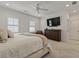 Well-lit bedroom with neutral tones, spacious layout, dresser, and large flat screen television at 630 Brashy St, Woodstock, GA 30188