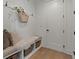 Mud room featuring a built-in bench, storage baskets, hooks and attractive white paneling at 630 Brashy St, Woodstock, GA 30188