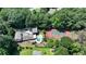 Expansive aerial view of a home with a pool, tennis court, lush landscaping, and mature trees on a large lot at 1024 Lake Charles Dr, Roswell, GA 30075