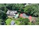 Expansive aerial view of a home with a pool, tennis court, lush landscaping, and mature trees on a large lot at 1024 Lake Charles Dr, Roswell, GA 30075