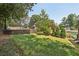 Expansive backyard featuring a tennis court, lush greenery, and a glimpse of the inviting pool area at 1024 Lake Charles Dr, Roswell, GA 30075