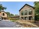 Stone home with a lush lawn, rose bushes, large arched windows, and a glimpse of the attached garage at 1024 Lake Charles Dr, Roswell, GA 30075