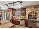 Spacious kitchen featuring custom cabinetry, stainless steel appliances, and stone backsplash with a cooktop at 1024 Lake Charles Dr, Roswell, GA 30075