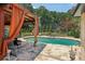 Inviting outdoor space showcasing a pool, grill, stone patio, and cozy cabana draped with orange curtains, perfect for gatherings at 1024 Lake Charles Dr, Roswell, GA 30075
