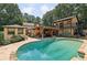 Resort-style backyard featuring a sparkling pool, covered outdoor seating, stone decking, and lush landscaping, creating a private oasis at 1024 Lake Charles Dr, Roswell, GA 30075