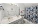 A tidy bathroom features a double sink vanity, shower with blue shower curtain at 105 Postwood Dr, Fayetteville, GA 30215