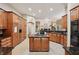 Spacious kitchen features wood cabinets, granite countertops, and island gas cooktop at 105 Postwood Dr, Fayetteville, GA 30215