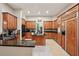 Well-lit kitchen featuring dark countertops, wooden cabinets, island, and tiled floors at 105 Postwood Dr, Fayetteville, GA 30215