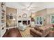 Cozy living room features a white brick fireplace, hardwood floors, and an area rug at 105 Postwood Dr, Fayetteville, GA 30215