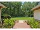 Manicured backyard with brick pathway invites peaceful relaxation amidst lush greenery and trees at 105 Postwood Dr, Fayetteville, GA 30215