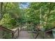 Inviting back deck with stairs, railing and peaceful views of the surrounding lush trees and foliage at 1270 Taylor Oaks Dr, Roswell, GA 30076
